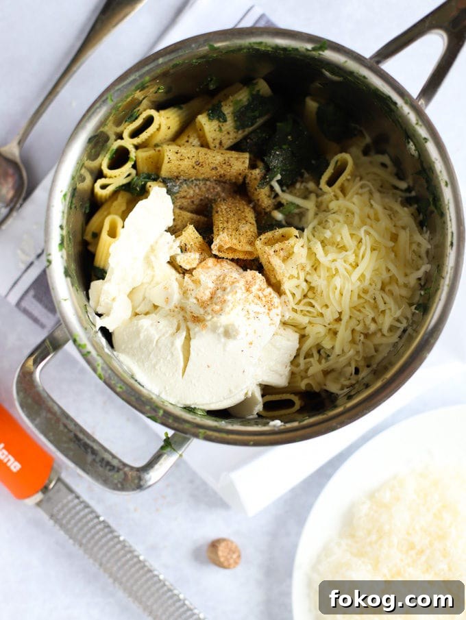 Saucepan with vegetables, and cheese ready to be mixed.