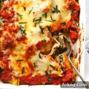 A dish with cooked Spinach and Ricotta Pasta Bake, topped with cheese, ready to be served.