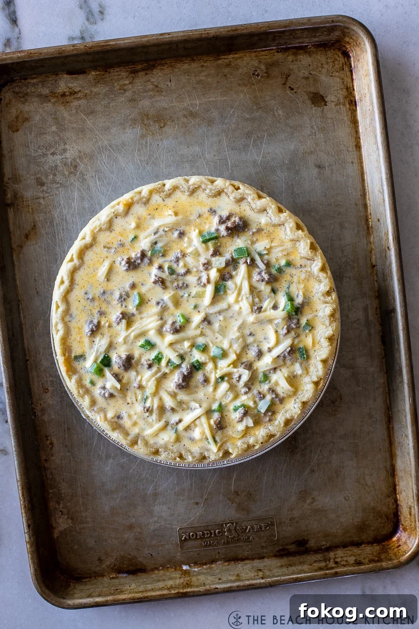 Overhead photo of a prebaked sausage pepper and onion quiche
