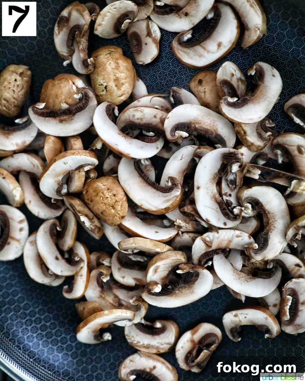 sliced mushrooms in a cast iron skillet.