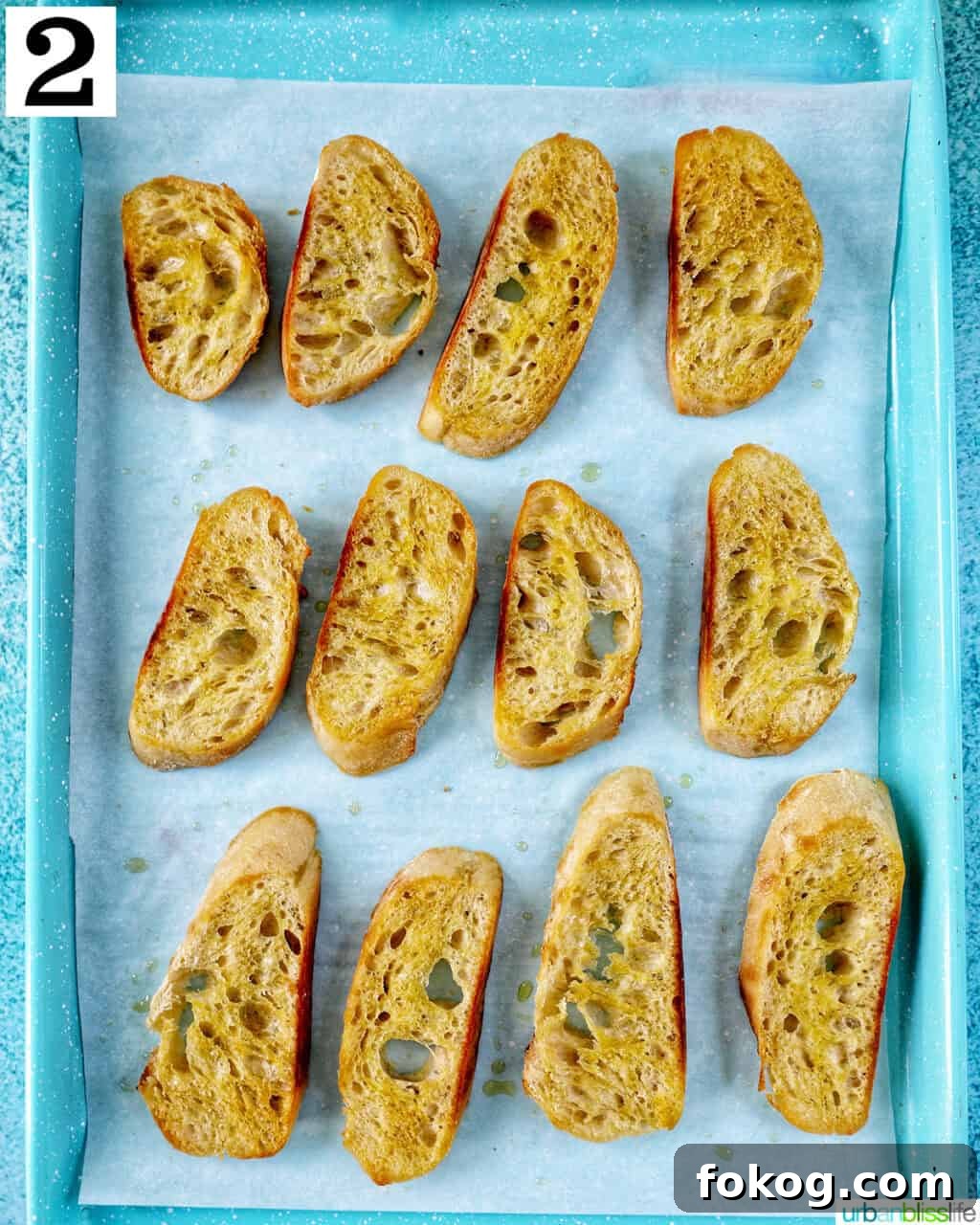 sliced baguette with olive oil on a baking sheet.