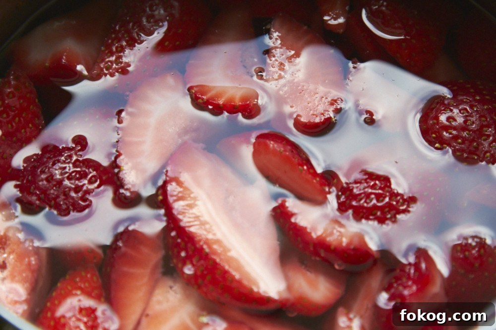Sliced strawberries submerged in water.