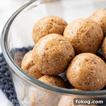 Almond date Protein Balls stacked in glass bowl.