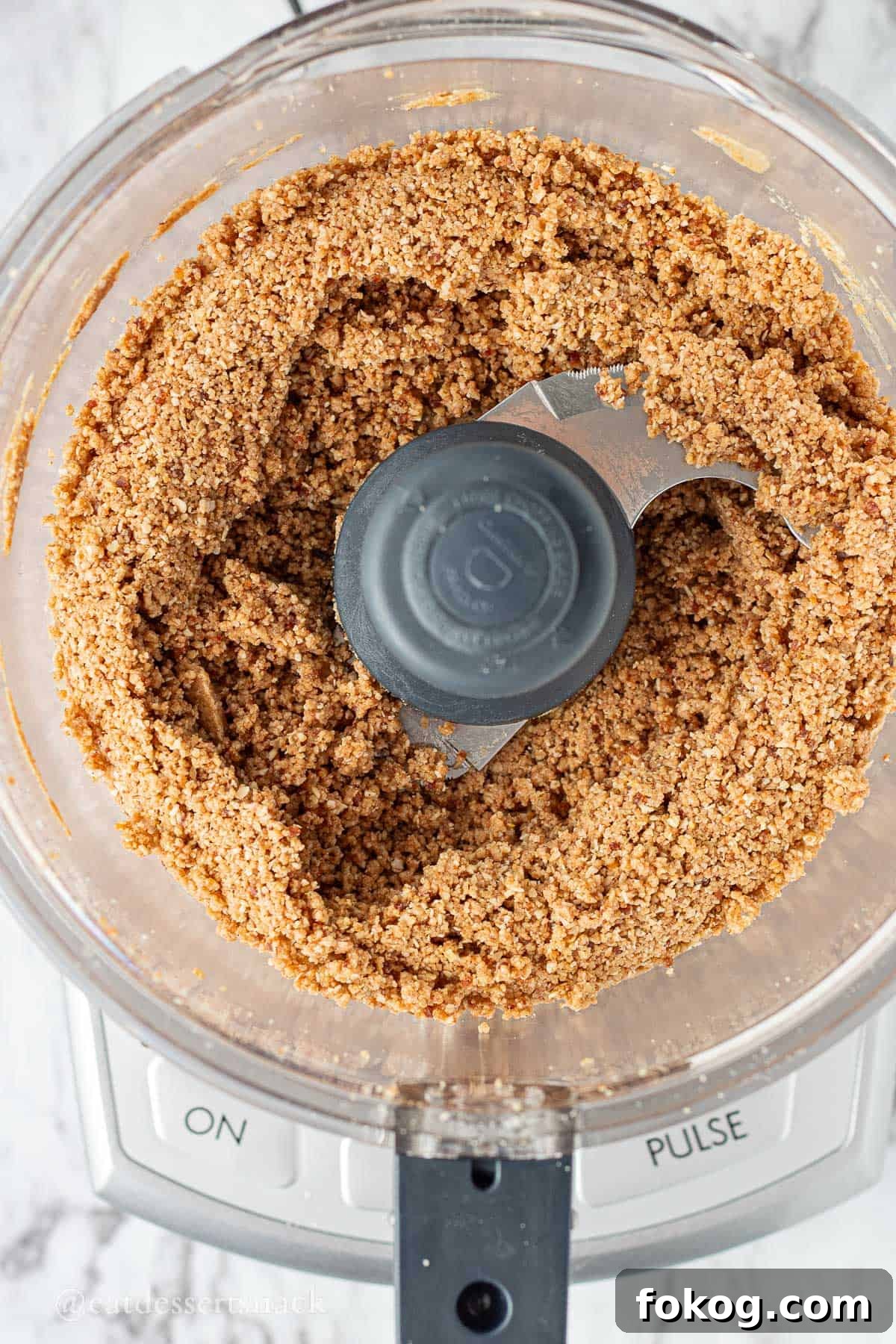 Mixed almond oats, almond flour, honey, almond butter, protein powder, honey, and vanilla in bowl of food processor.