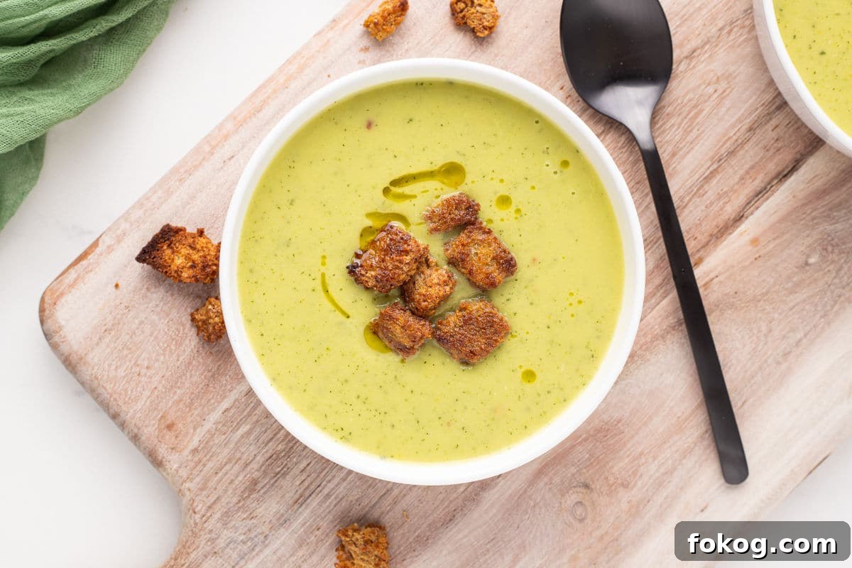 Green soup with croutons in a bowl.