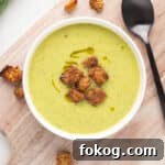 Green soup with croutons in a bowl.