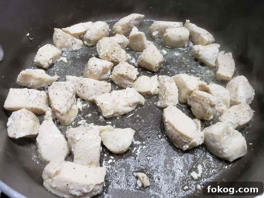 Creamy Chicken Fettuccine Alfredo Recipe for Weeknight Dinner 6 diced chicken cooking in a frying pan.