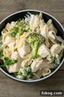 Creamy Chicken Fettuccine Alfredo Recipe for Weeknight Dinner 10 Chicken Fettuccine Alfredo with Broccoli in a bowl with a fork.