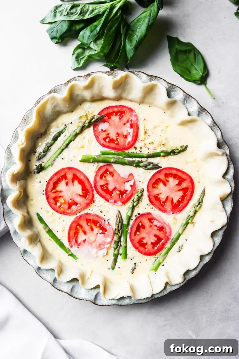 Fresh basil, uncooked tomato and asparagus quiche.
