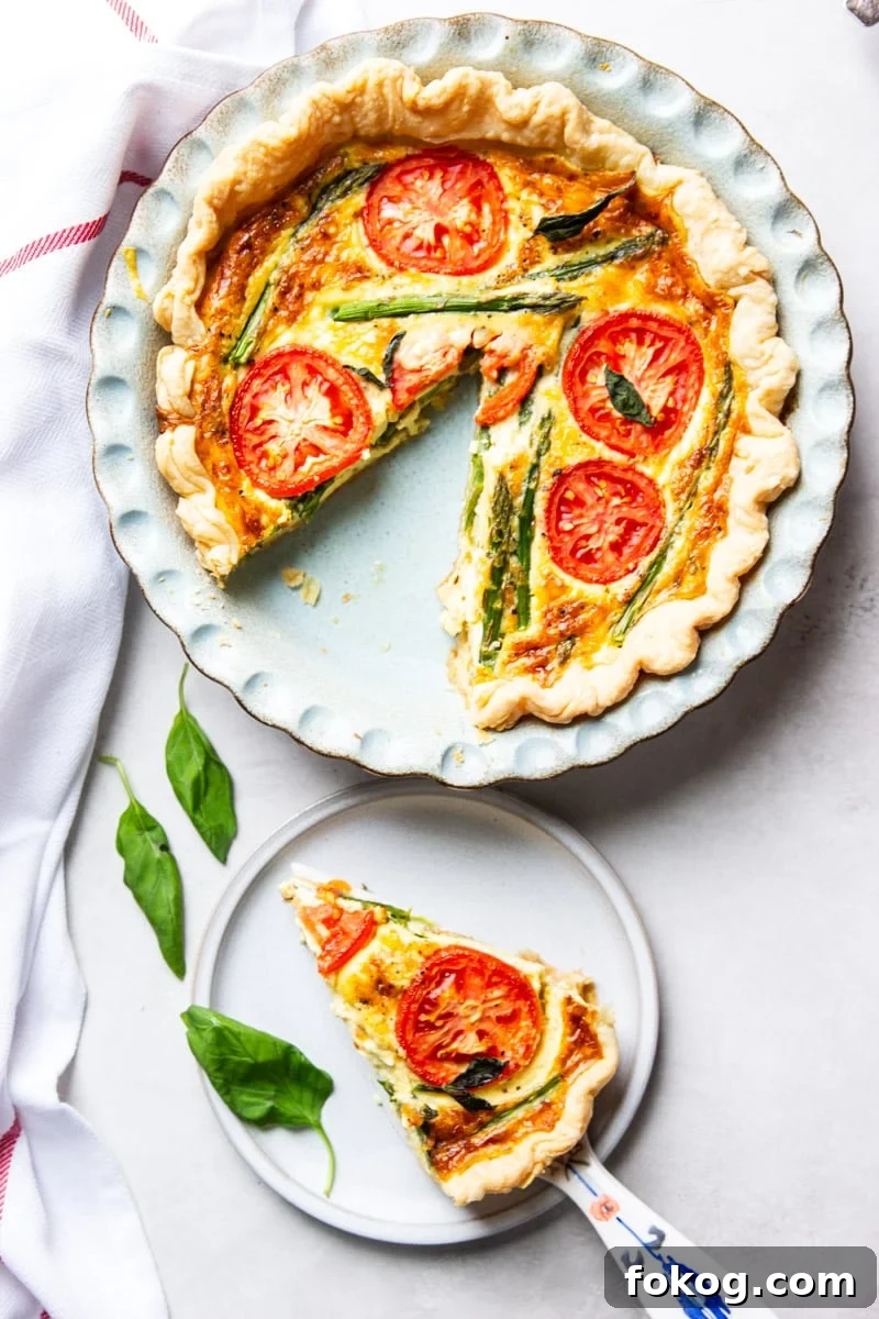 Tomato and asparagus quiche, fresh basil, and a red and white dish towel. 