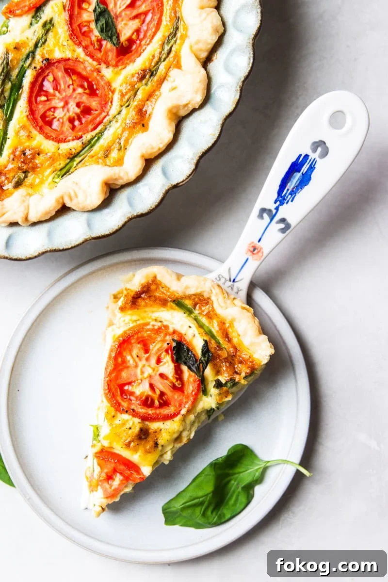 Asparagus and tomato quiche, fresh basil and a colored spoon. 
