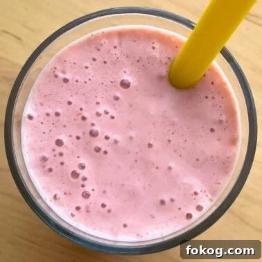 Strawberry Banana Yogurt Smoothie Recipe — Creamy & Refreshing 8 A close-up of a strawberry banana smoothie with Greek yogurt with a yellow straw.
