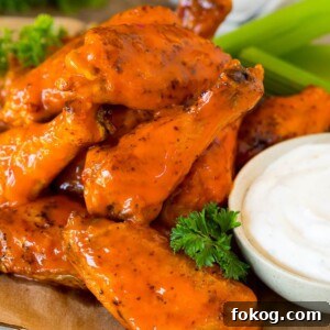 Air fryer chicken wings coated in buffalo sauce and served with ranch and celery.