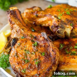 A plate of air fryer pork chops garnished with parsley.