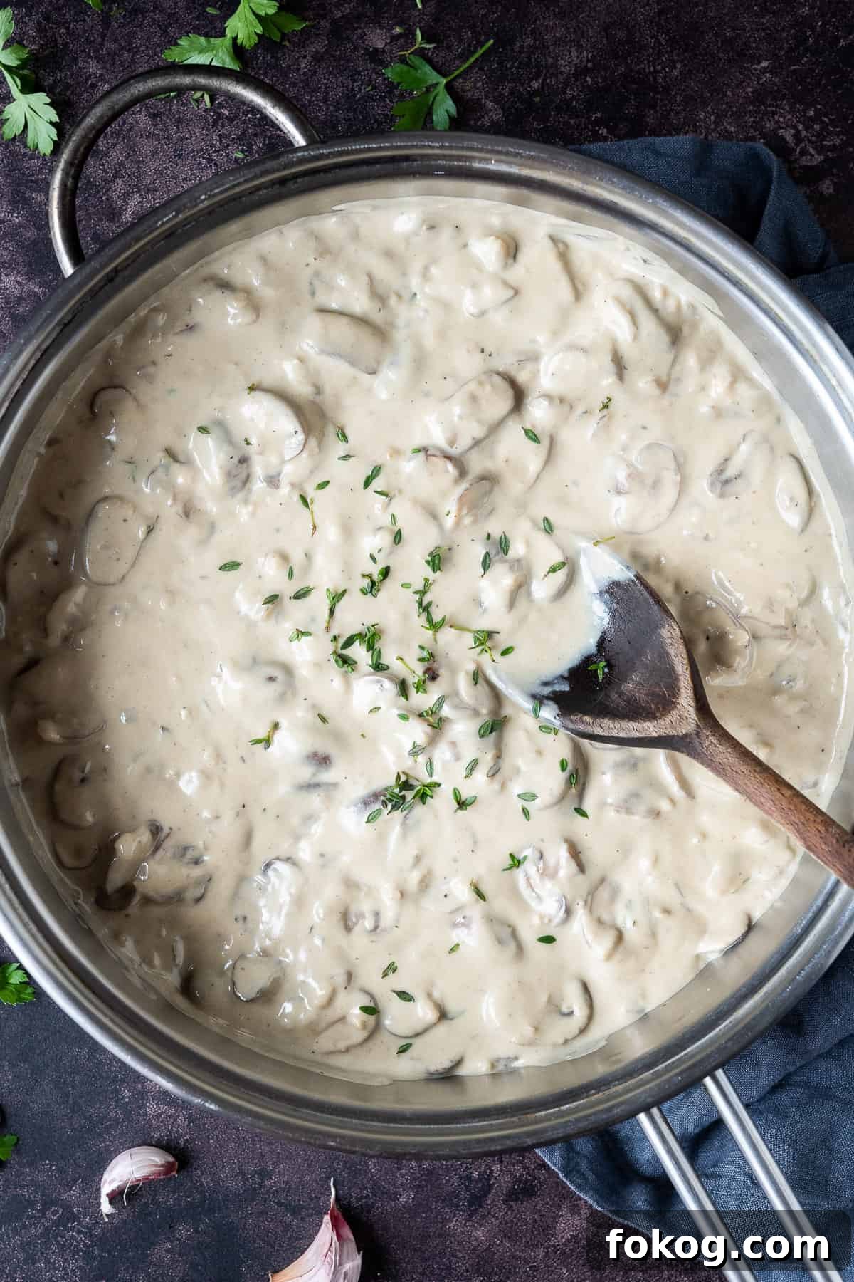 Creamy vegan mushroom pasta with truffle oil - this incredible vegan pasta is rich, creamy and delicious. With a cashew cream sauce and truffle oil it is an indulgent, comforting and impressive meal that is easy to make but tastes amazing! #veganmeal #dairyfree #plantbased A pan of vegan creamy mushroom sauce on a dark background.
