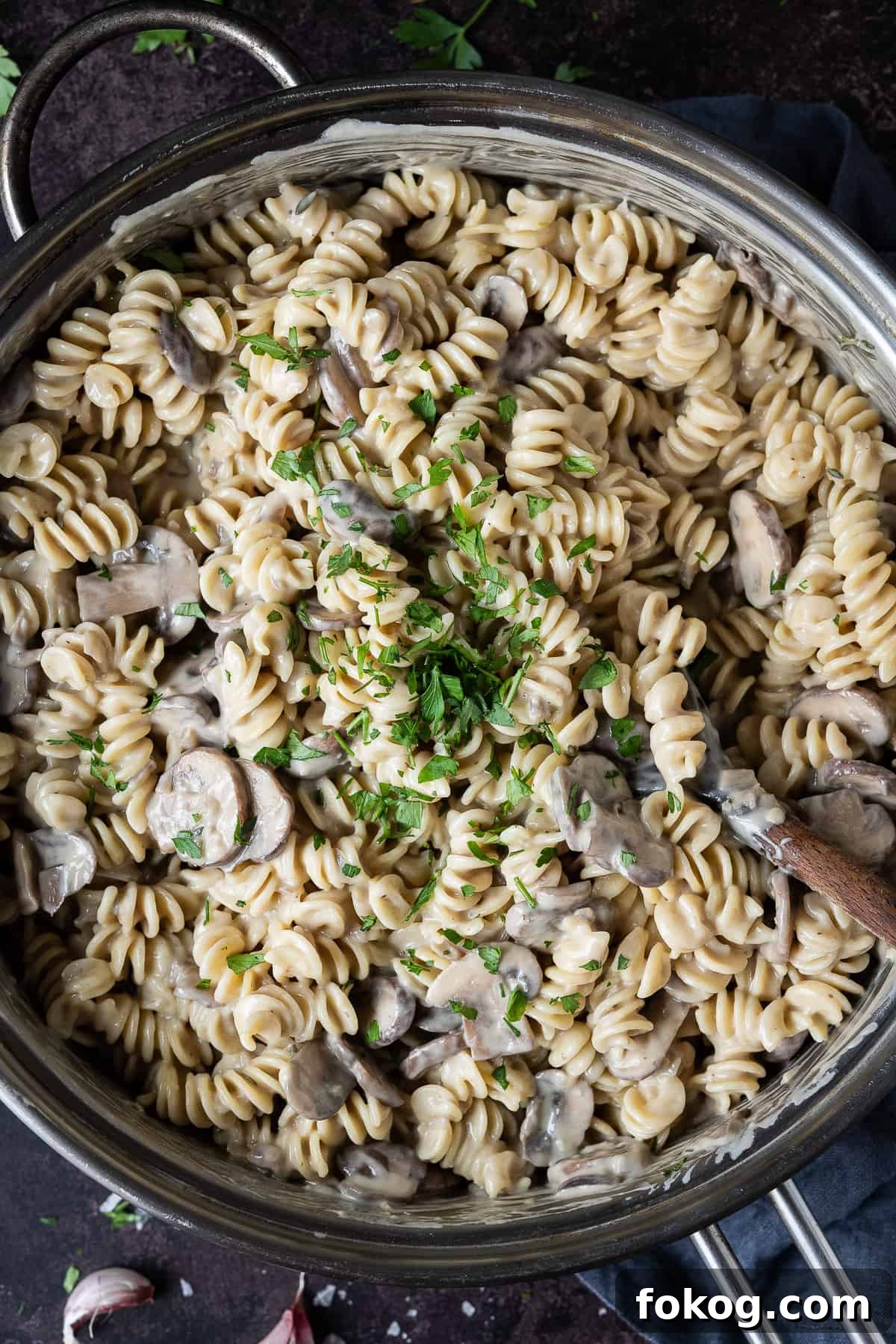 Creamy vegan mushroom pasta with truffle oil - this incredible vegan pasta is rich, creamy and delicious. With a cashew cream sauce and truffle oil it is an indulgent, comforting and impressive meal that is easy to make but tastes amazing! #veganmeal #dairyfree #plantbased Close up of creamy vegan mushroom pasta topped with fresh parsley.