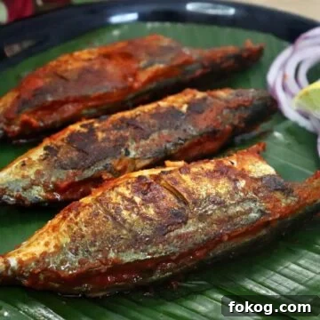 recheado mackerels served on a plate with lemon wedges and onion rings. Recheado masala fish recipe.