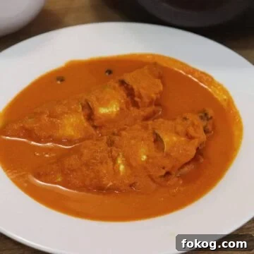 goan fish curry with coconut served in a white bowl.