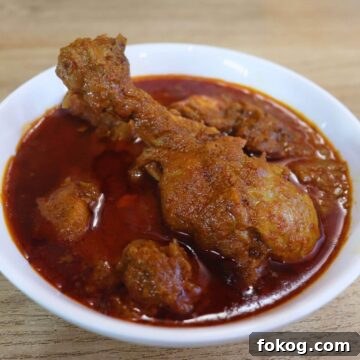malvani chicken curry in a white colored bowl.