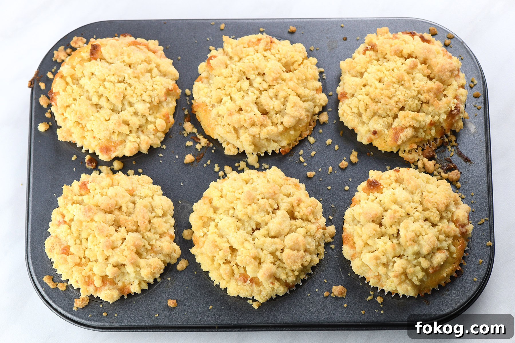 Lemon Curd Muffins with Zesty Citrus Filling 5 batch of lemon curd muffins with crumb topping baked in muffin pan