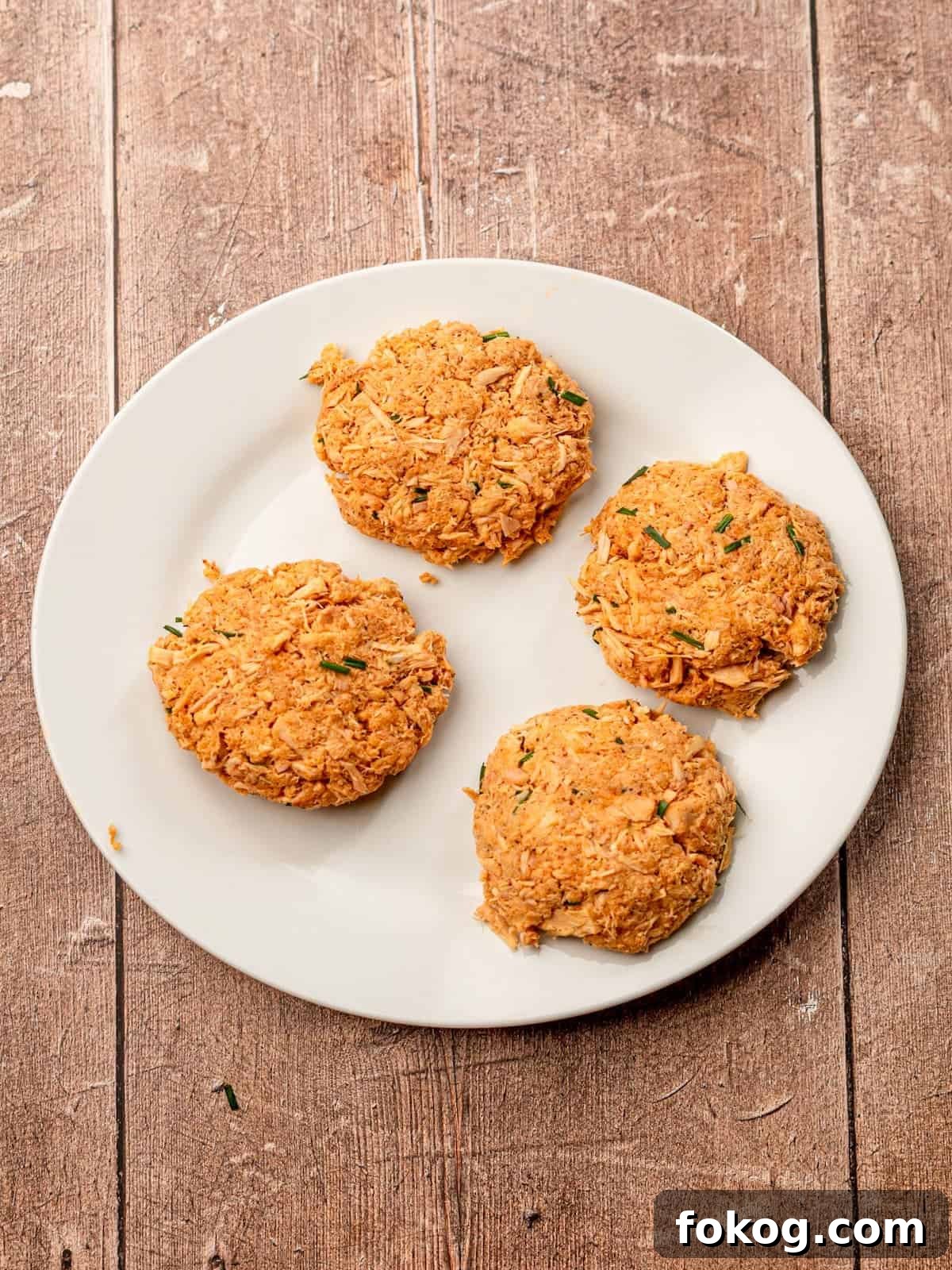 Tuna patties on a white plate before cooking.
