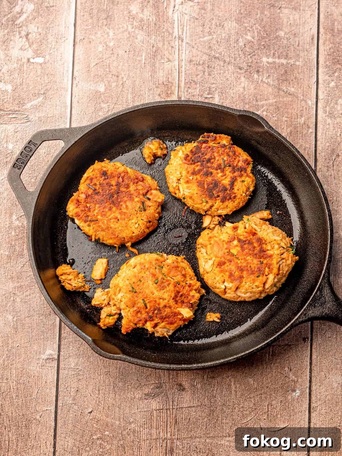 Cooked tuna cakes in a cast iron pan.