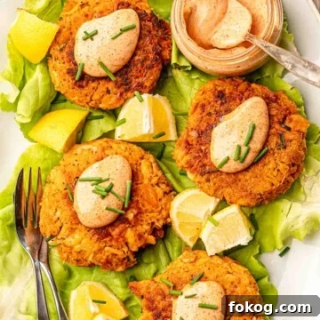 Tuna patties topped with aioli and chives with a bowl of aioli on the side.