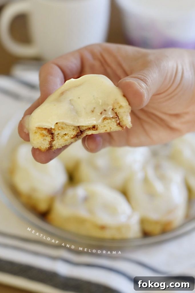 cut open cinnamon roll in hand