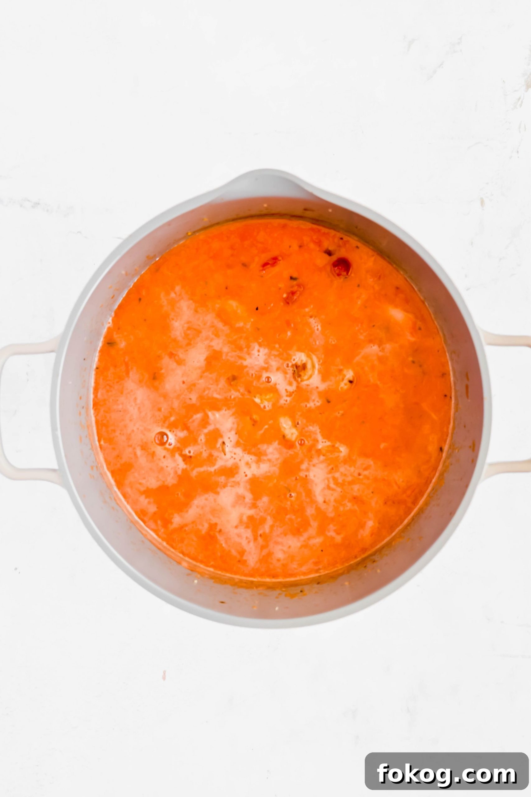 Simmering pot of broth and veggies for Cauliflower Gnocchi Soup with Sausage.