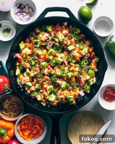 Spicy Cauliflower Nachos with Melted Cheese & Jalapeños 7 Spicy cauliflower nachos after being baked in a cast iron pan