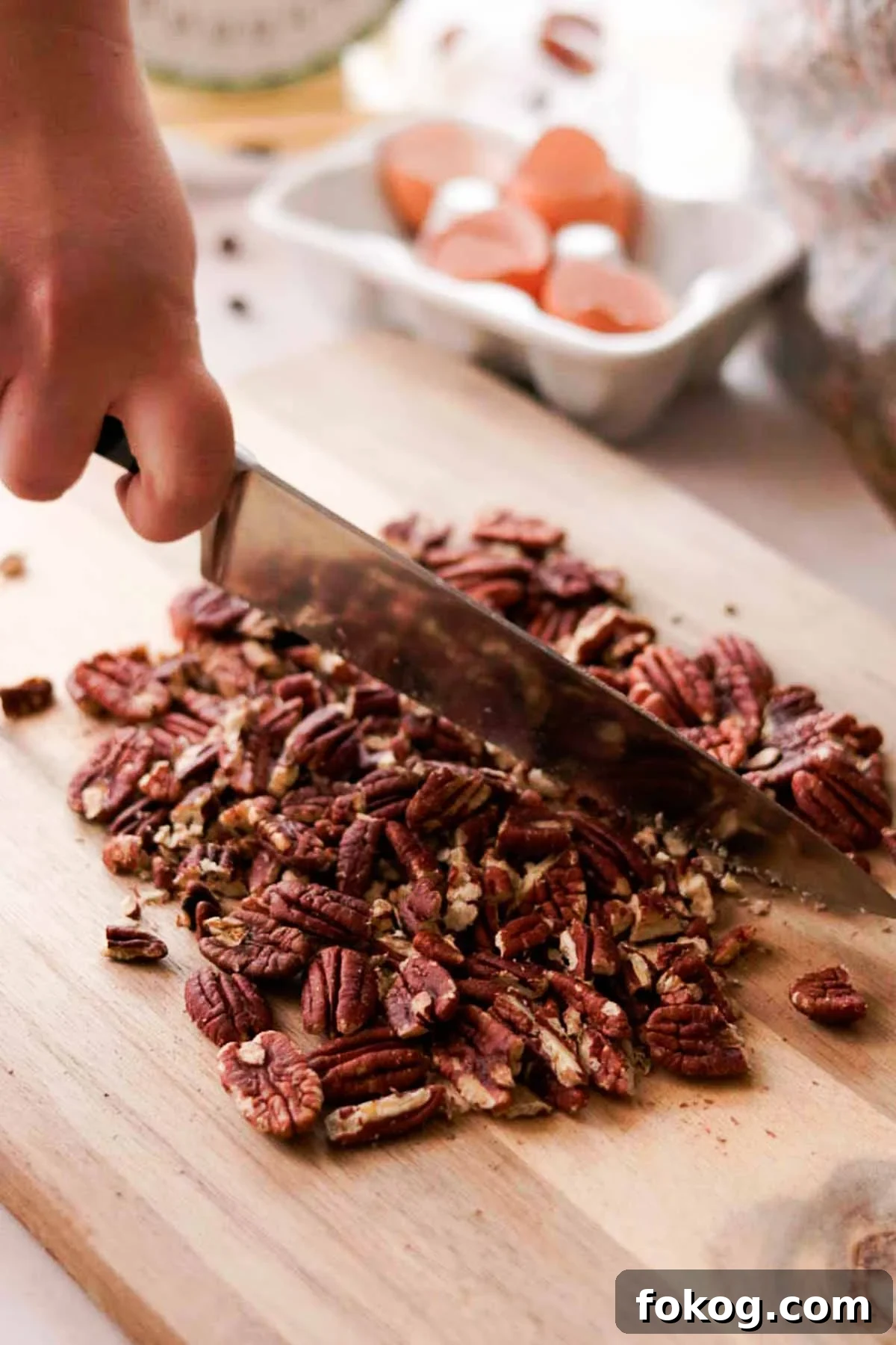 Decadent Pecan Pie Brownies Recipe — Gooey Pecan Swirl Dessert 11 chopping pecans with a knife on cutting board