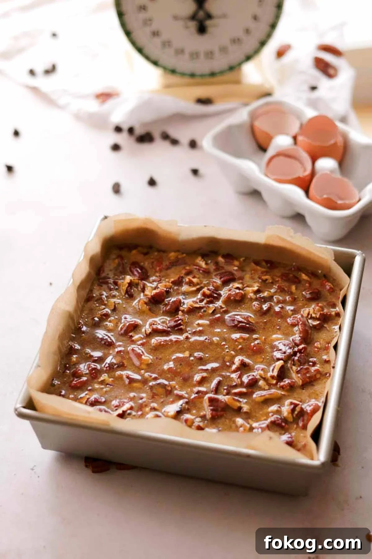 Decadent Pecan Pie Brownies Recipe — Gooey Pecan Swirl Dessert 15 brownie batter in a square tin pan with a layer of pecan butter topping