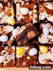 brownies topped and filled with mini eggs on parchment paper
