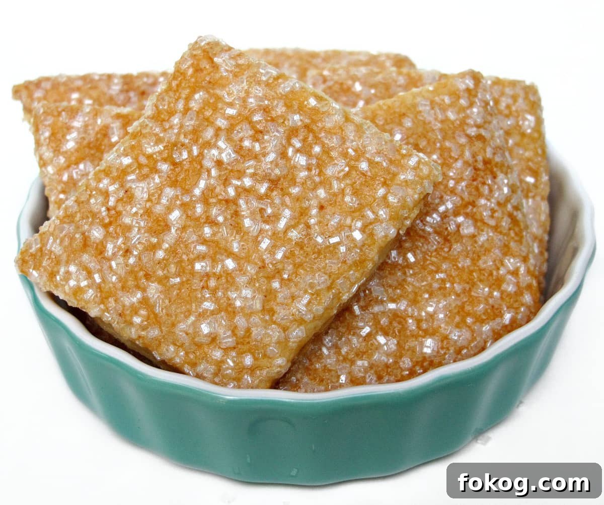Maple Crisp Cookies with a Shimmering Sugar Glaze 2 A bowl full of square pastry dough cookies coated in sparkling sugar.
