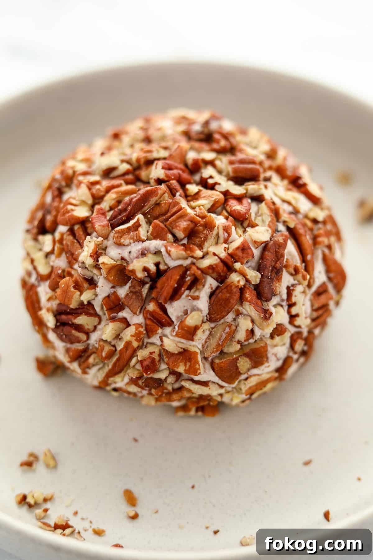 Creamy Boursin Cheese Ball Recipe for Parties and Holidays 7 A cheese ball coated in chopped pecans.
