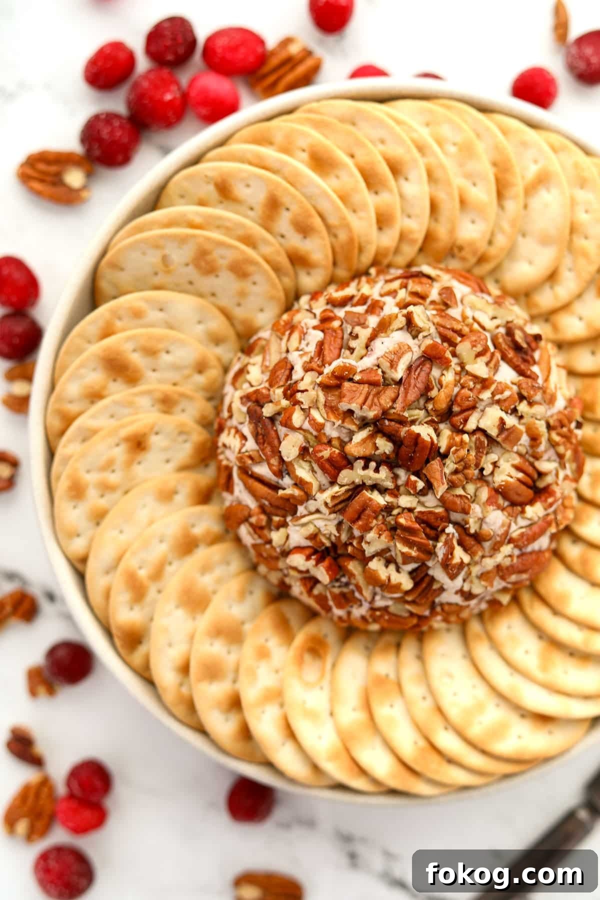 Creamy Boursin Cheese Ball Recipe for Parties and Holidays 8 A pecan-coated cheese ball surrounded by crackers.