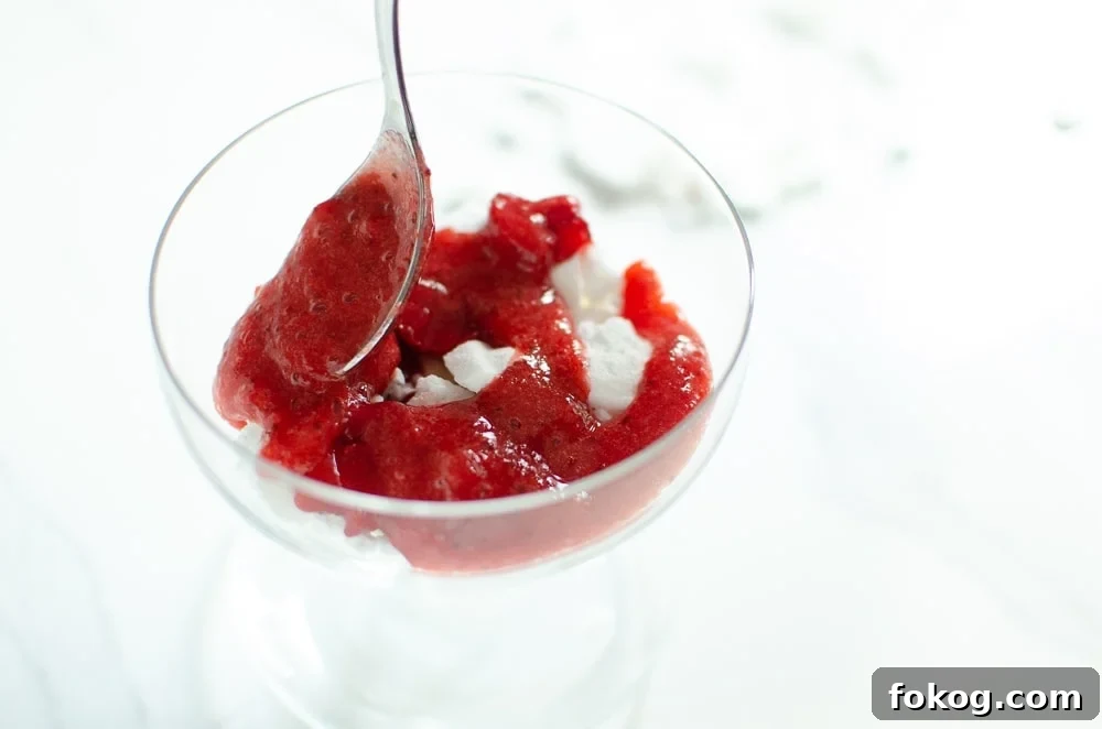 Strawberry sauce being placed on top of the cream to make Eton mess dessert