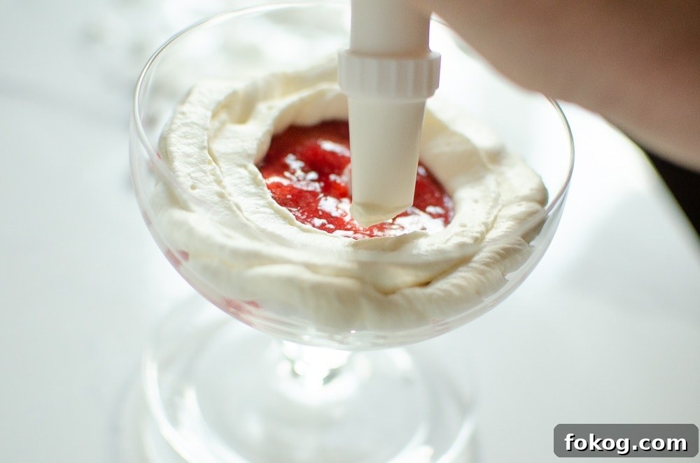 cream being piped on strawberry sauce
