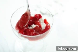 Strawberry sauce being placed on top of the cream to make Eton mess dessert