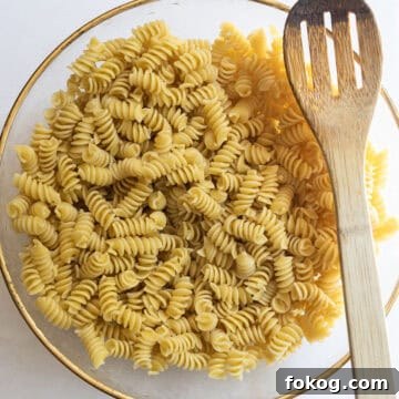Classic Italian Pasta Salad Recipe with Tangy Vinaigrette and Veggies 5 pasta combined with olive oil in a bowl.