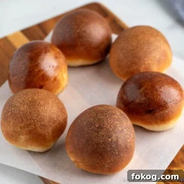 A circle of round dinner rolls each with a different finished glaze.