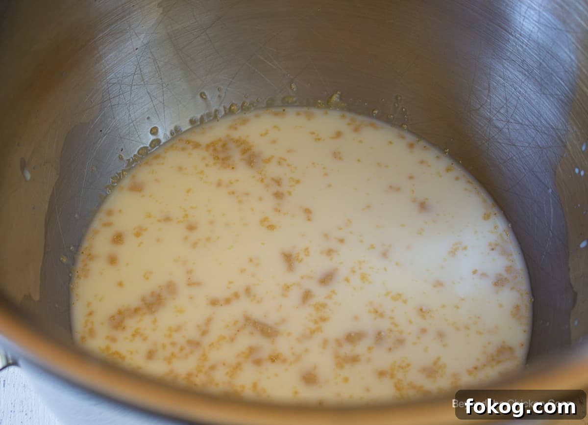 Yeast added to milk in a mixing bowl.