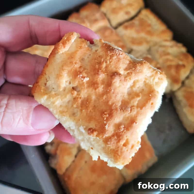 Simple Bisquick Recipes for Delicious Breakfasts and Snacks 10 7 Up biscuit being held above a pan of biscuits