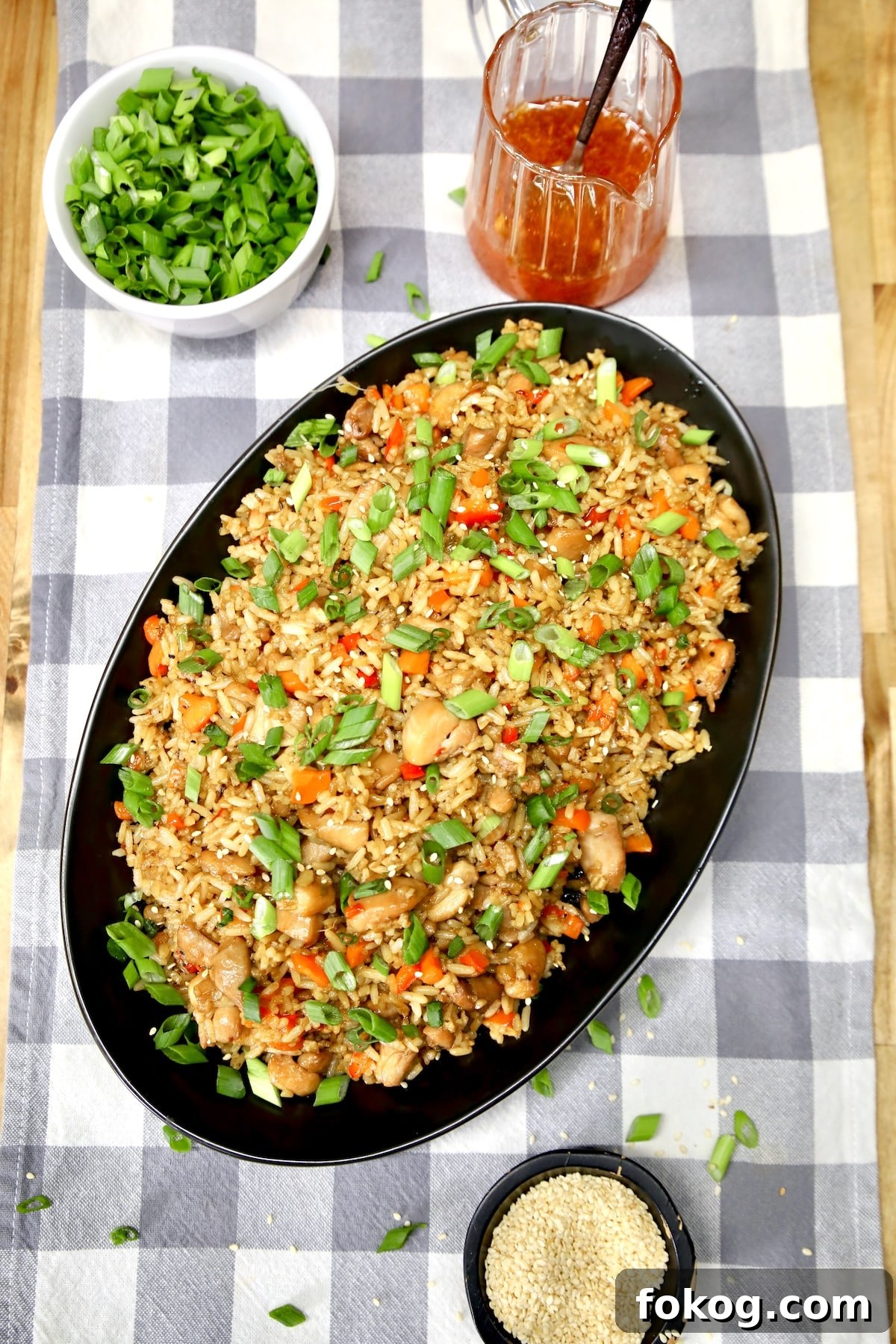 Platter of chicken fried rice, hot honey, green onions, sesame seeds.
