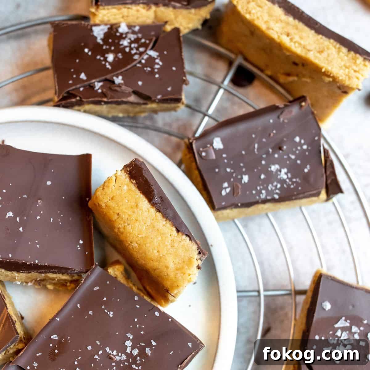 Buckeye Bars Recipe: Classic Peanut Butter Chocolate Treats 2 Bars on a white plate with a sprinkle of salt.