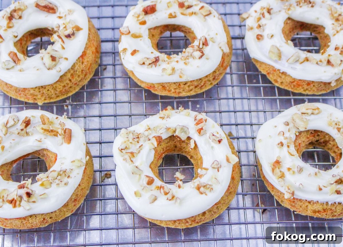 A few gluten and dairy free baked carrot cake donuts with nuts on top.