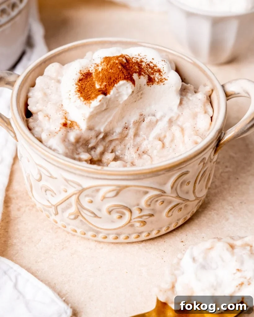 maple cinnamon rice pudding in a ramekin topped with whipped cream and cinnamon