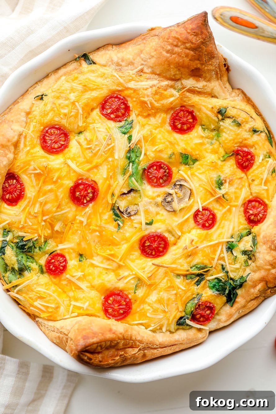 Close up on a baked JUST Egg quiche in a white pie plate.