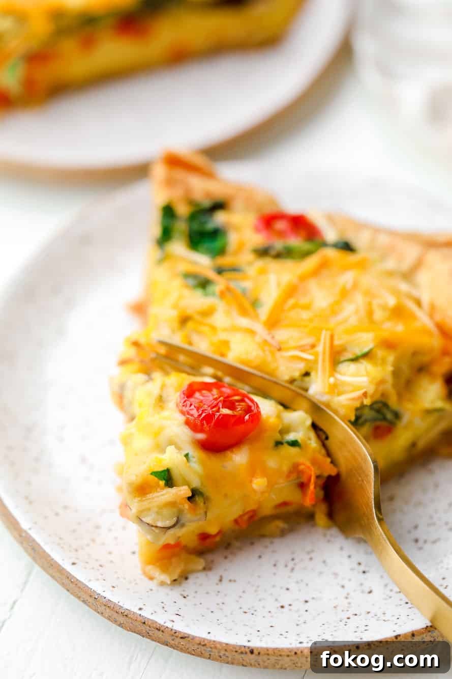 A fork taking a bite out of a slice of JUST Egg quiche.