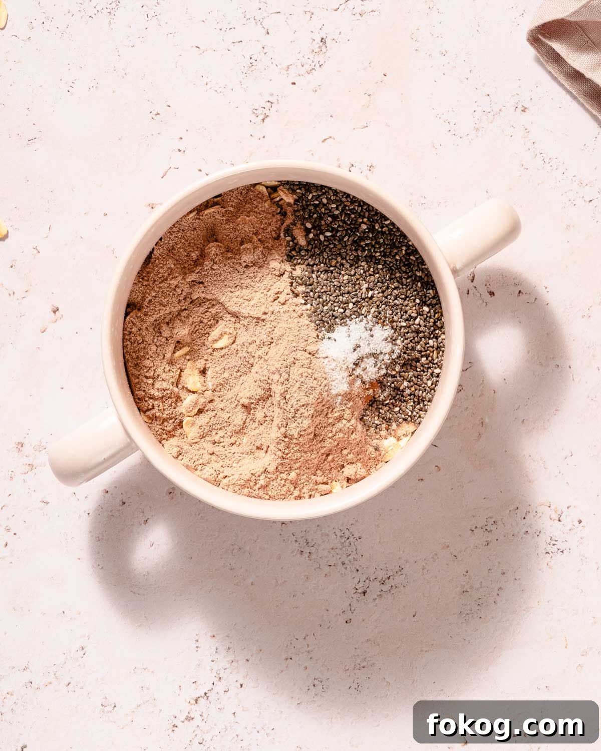 Creamy Chocolate Protein Overnight Oats 4 dry ingredients for chocolate overnight oats in mug.